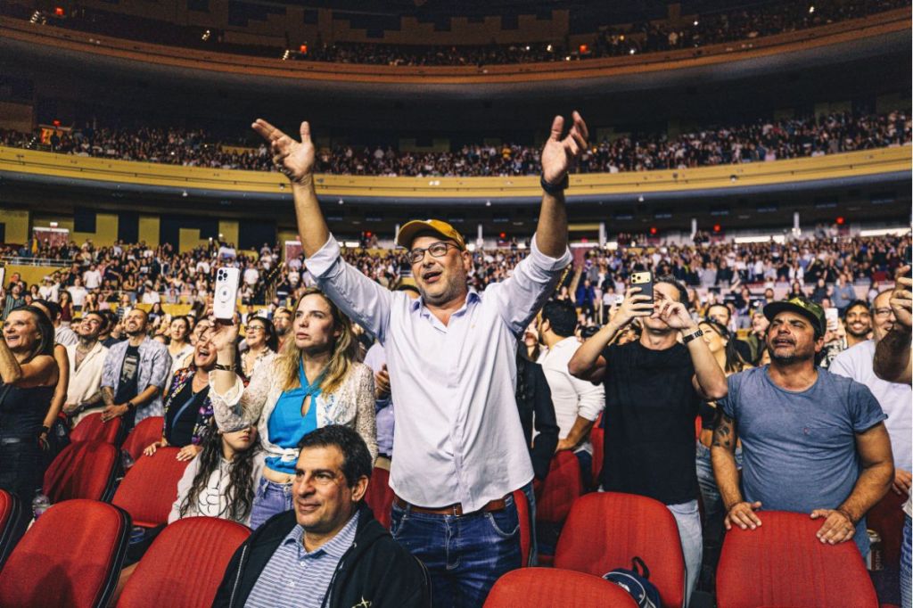 A man in the crowd at a concert standing up.