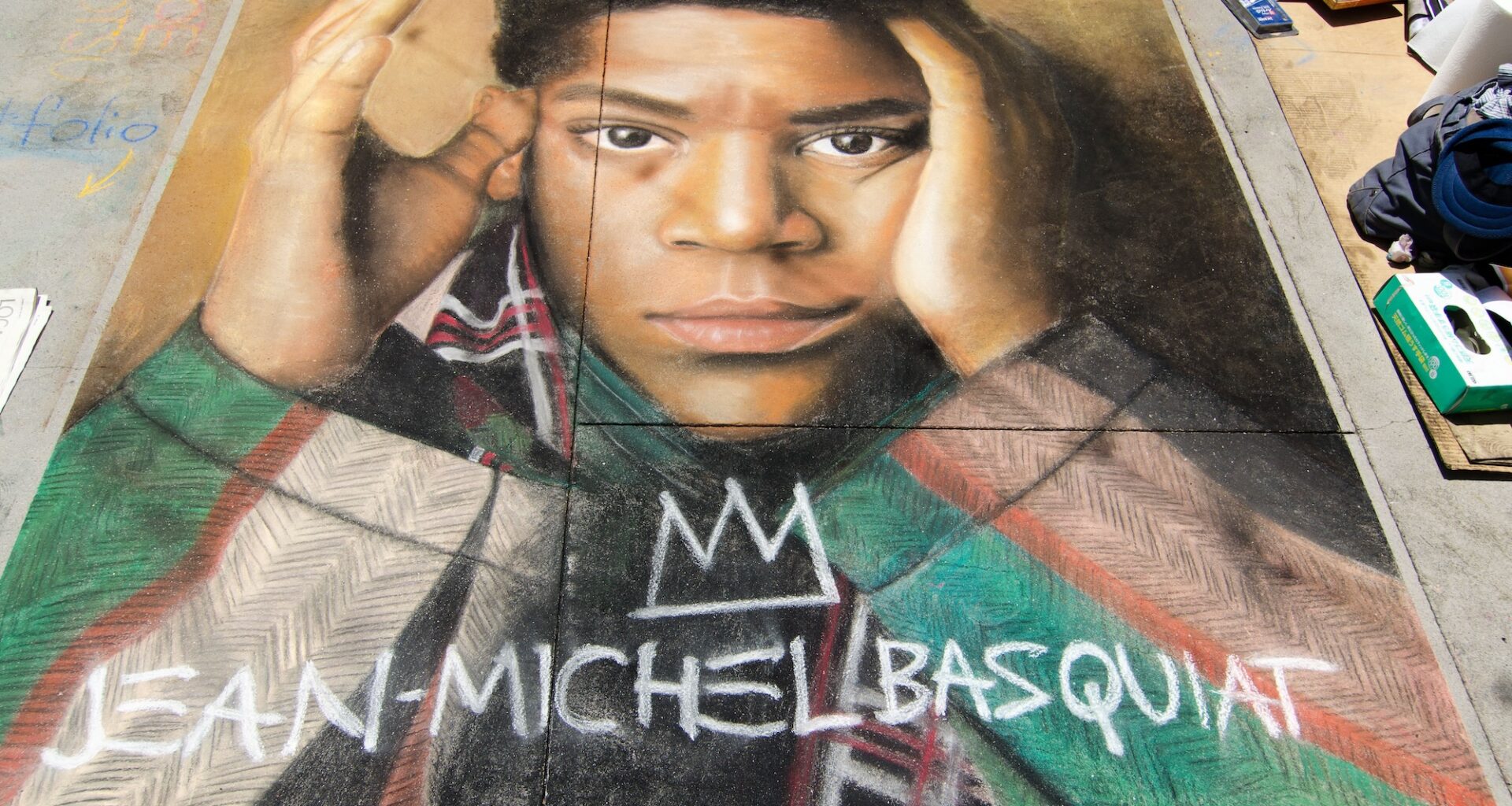 photo of a sidewalk mural depicting a photorealistic chalk drawing of the artist Jean-Michel Basquiat