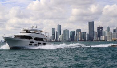 photo of a yacht cruising on the water with the Miami skyline behind it