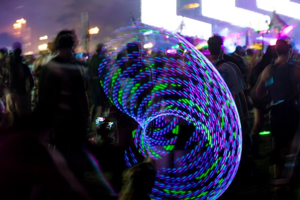 A hula hooper twirls and spins during EDC Orlando at...