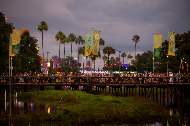 Festival attendees walk along Daisy Lane during EDC Orlando at...