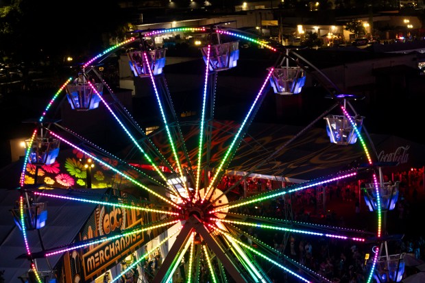 Festival attendees take a ride on the Ferris wheel during...