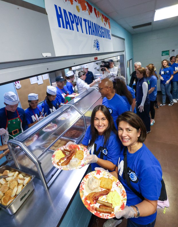 A THANKSGIVING TRADITION — Volunteers J.J. and Alexis Weltman plate...