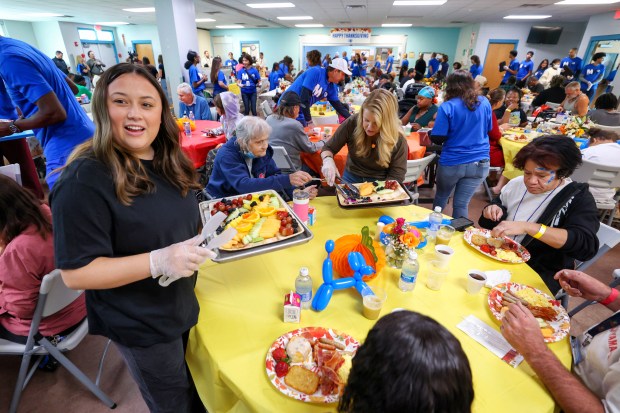 A THANKSGIVING TRADITION — Volunteer Cailee Kirkpatrick serves up fruit...