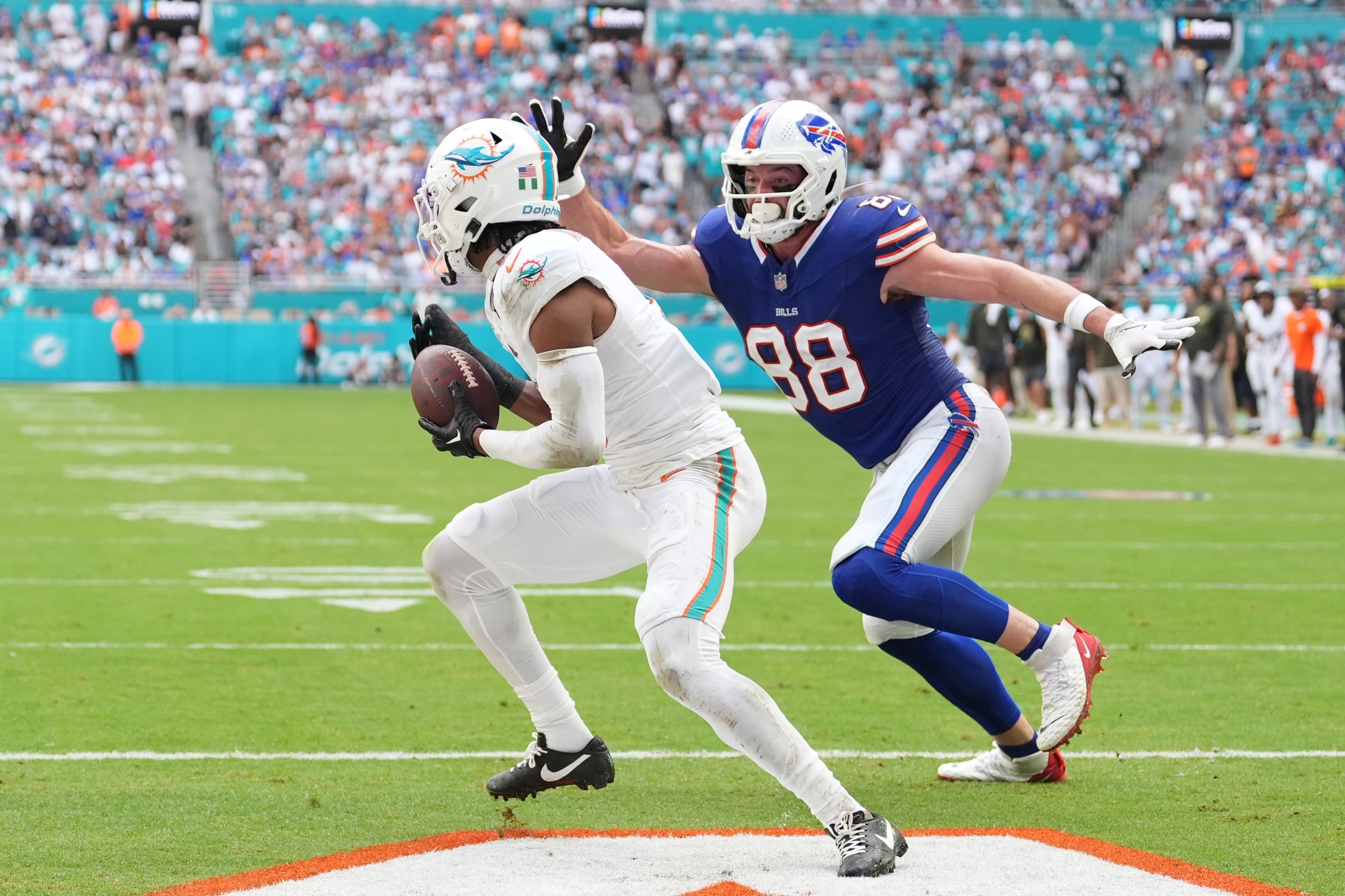 Miami Dolphins safety Ifeatu Melifonwu makes an interception against Buffalo Bills' Dawson Knox (88) during the second half of an NFL football game, Sunday, Nov. 9, 2025, in Miami Gardens, Fla. (AP Photo/Rebecca Blackwell)