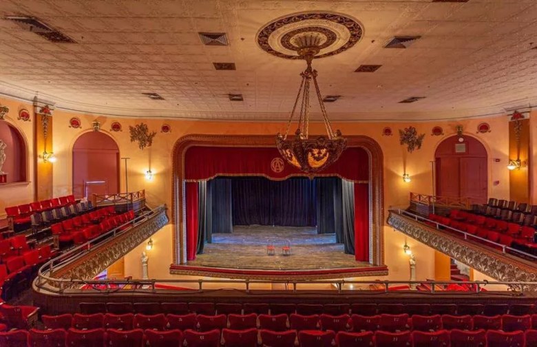 The ornate interior of the historic Centro Asturiano de Tampa theater, showing the stage, balcony, and rows of seating.