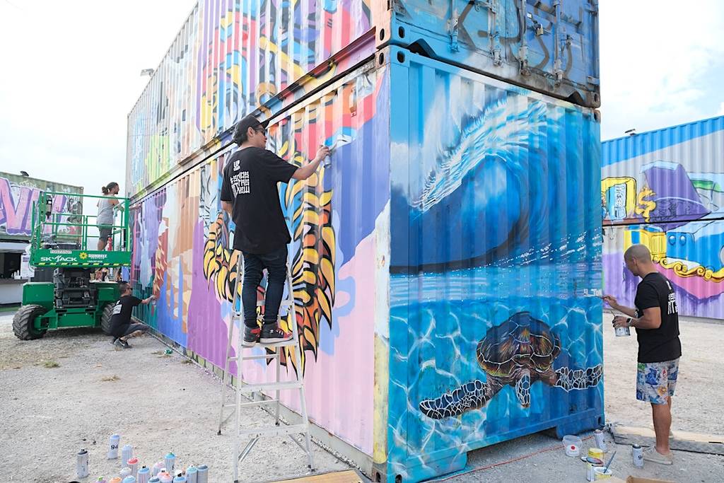Artists working on shipping containers at HIVE Wynwood