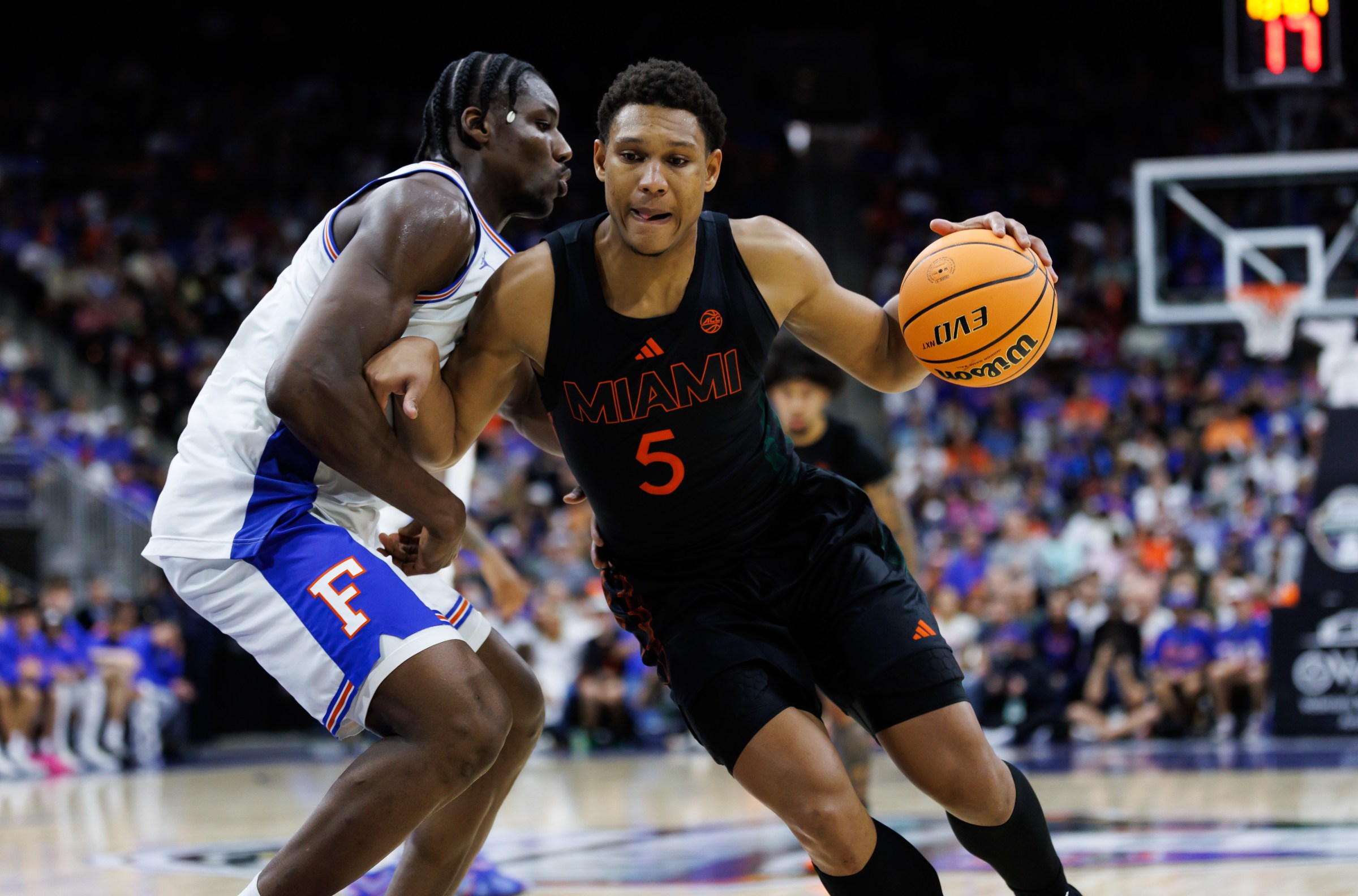 Nov 16, 2025; Jacksonville, Florida, USA; Miami Hurricanes forward Malik Reneau (5) drives to the basket at Florida Gators center Rueben Chinyelu (9) during the second half at VyStar Veterans Memorial Arena. Mandatory Credit: Matt Pendleton-Imagn Images