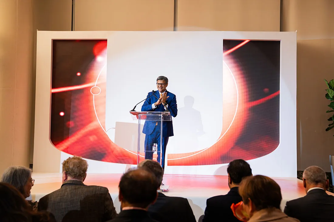 Dr. Dipen Parekh speaking from a podium at the UHealth SoLé Mia VIP event