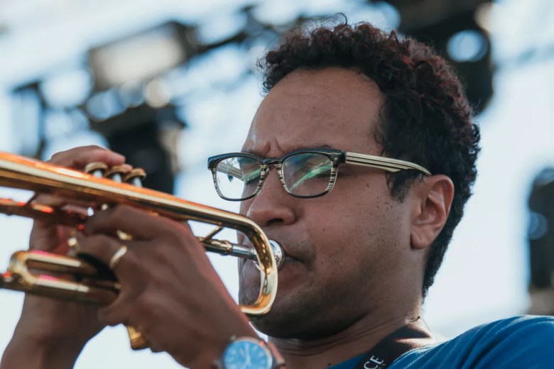 Jazz trumpeter James Suggs is photographed playing his instrument during a live outdoor performance.