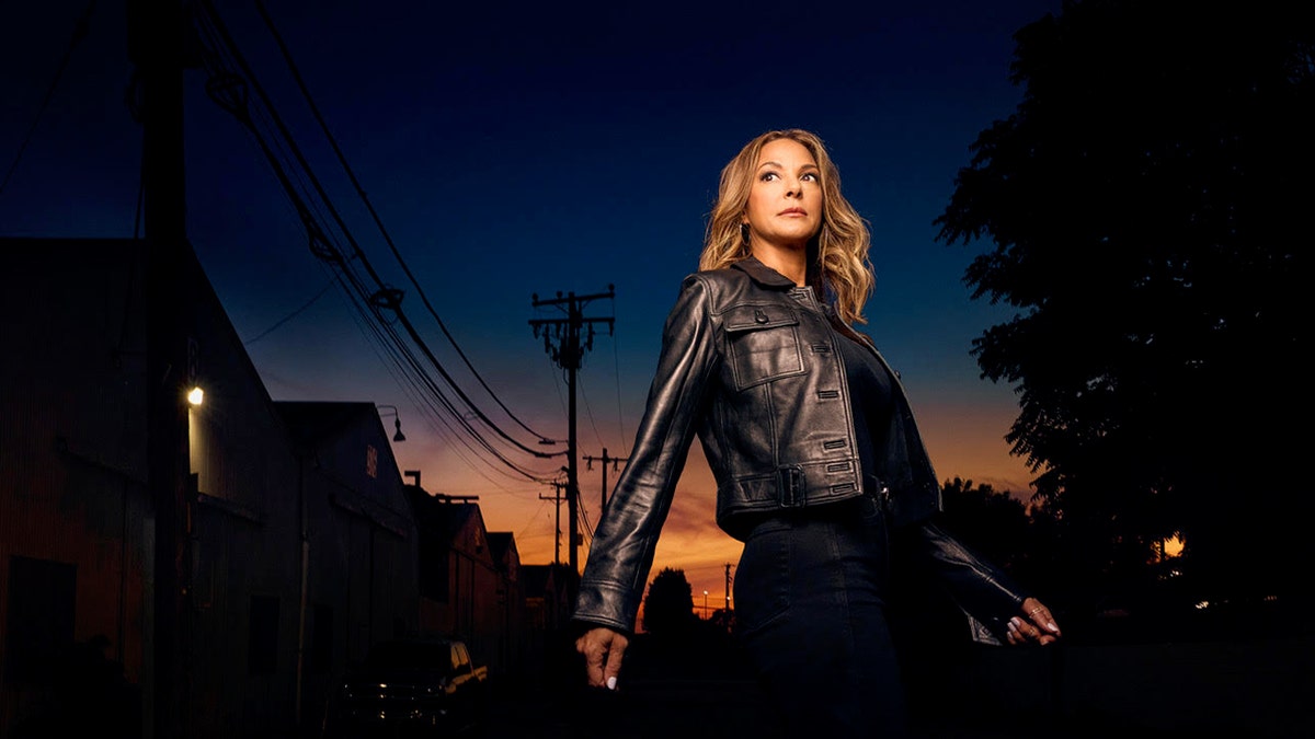 Eva LaRue posing in the evening wearing a leather jacket.