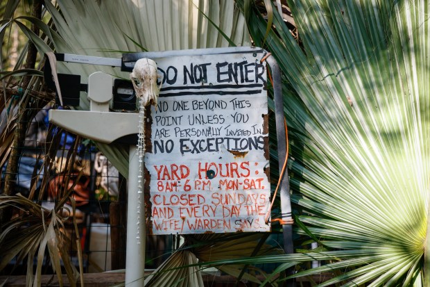 A sign is posted at a homeless encampment in a...