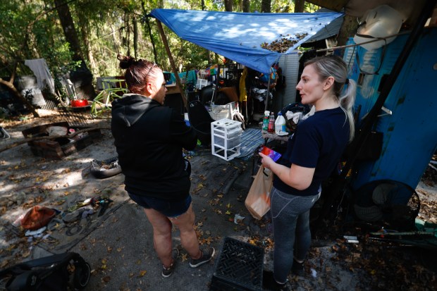 Lauren Tucker speaks with Stacey, a homeless individual who lives...