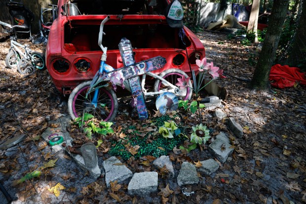 A makeshift memorial for homeless individuals who have died in the woods sits outside a homeless encampment in a wooded area in Bithlo on Monday, November 24, 2025. (Rich Pope/Orlando Sentinel)