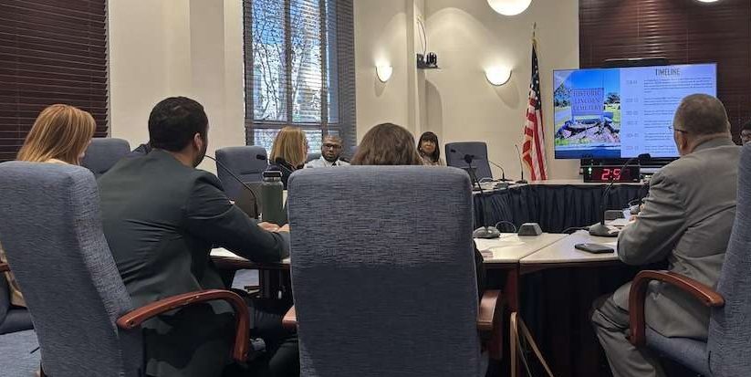 men and women sitting around a table in a conference room.