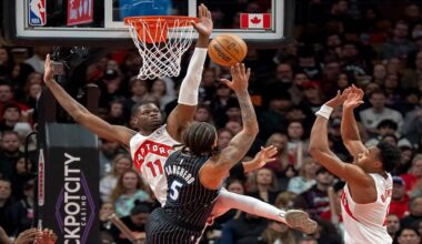 Toronto Raptors center Mo Bamba (11) and forward Scottie Barnes, right, defend against Orlando Magic forward Paolo Banchero (5) as he shoots during first half NBA action in Toronto on Monday Dec. 29, 2025. THE (Frank Gunn/The Canadian Press via AP)