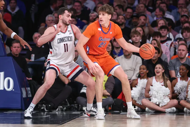 Dec 9, 2025; New York, New York, USA; Florida Gators forward Alex Condon (21) looks to post up against UConn Huskies forward Alex Karaban (11) in the first half at Madison Square Garden. Mandatory Credit: Wendell Cruz-Imagn Images