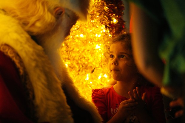 A little girl meets Santa, a.k.a. Richard Adler of West Palm Beach, during a Christmas tree lighting ceremony at the Promenade at Coconut Creek. Adler is a real beard Santa, a prized version of Santa actors who are in short supply this holiday season. Saturday, Nov. 22, 2025 (Jim Rassol/Contributor).