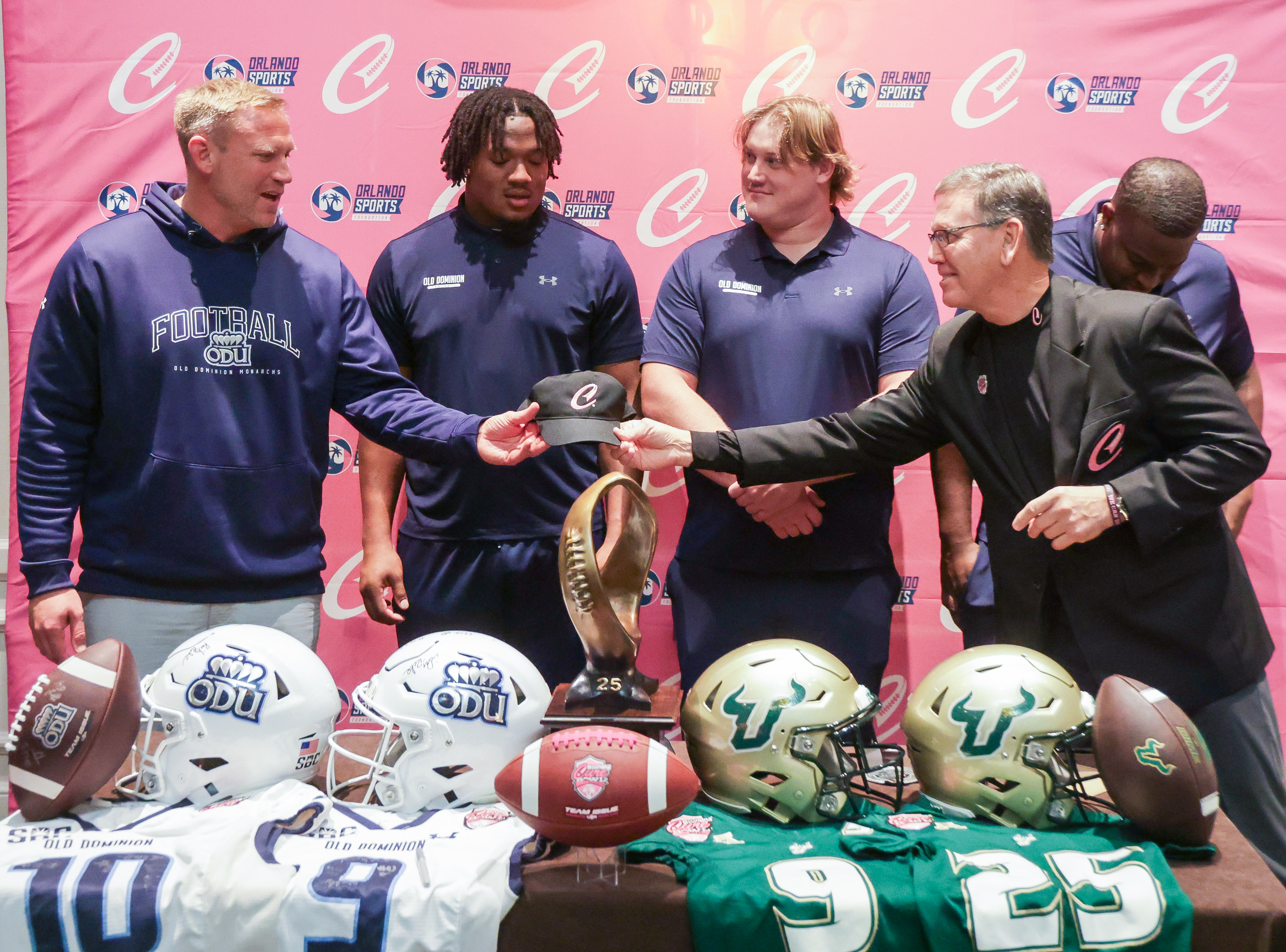 Alan Gooch, CEO of the Orlando Sports Foundation, right, presents...