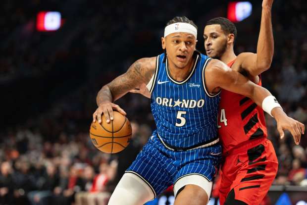 Orlando Magic forward Paolo Banchero, left, dribbles against the Portland Trail Blazers forward Kris Murray, right, during the first half of an NBA basketball game on Tuesday in Portland, Oregon. (Howard Lao/Associated Press)