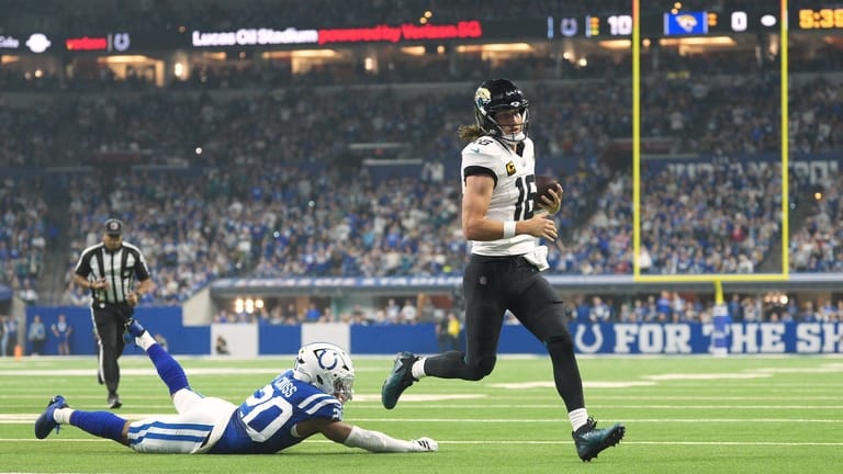 Jacksonville Jaguars quarterback Trevor Lawrence (16) scores past Indianapolis Colts...