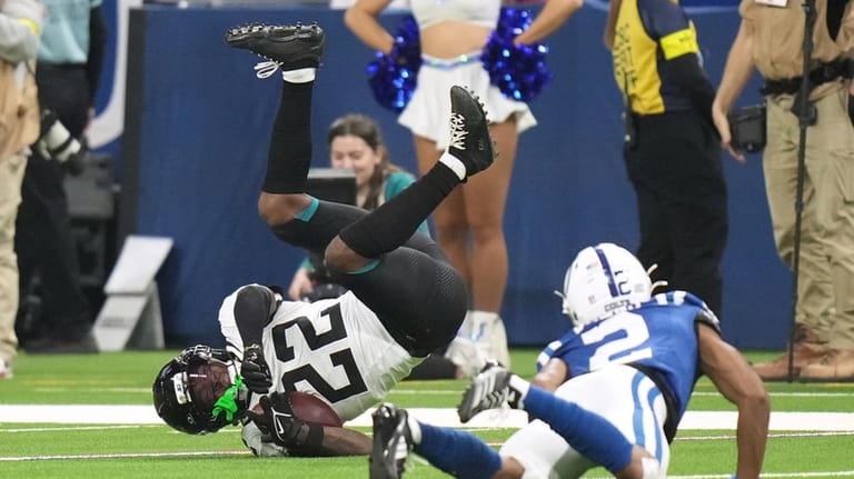 Jacksonville Jaguars cornerback Jarrian Jones (22) tumbles after intercepting a...
