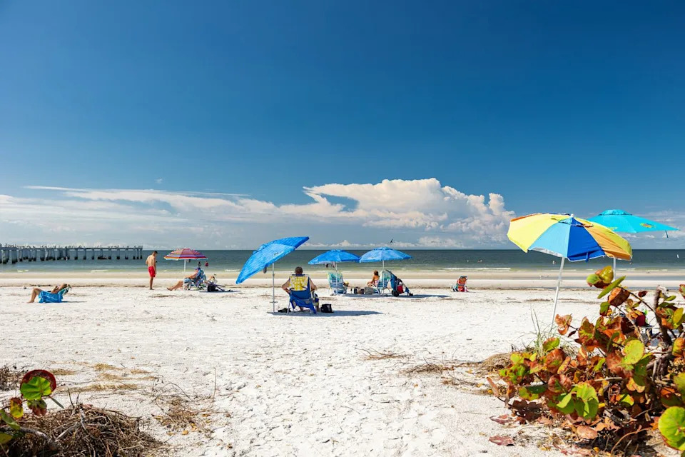Kristjan Veski/Travel + Leisure Colorful umbrellas on a beach in Fort Myers, Florida.