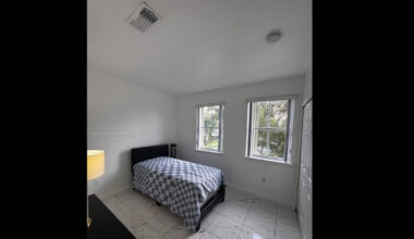 A photo of a small bedroom with a bed.