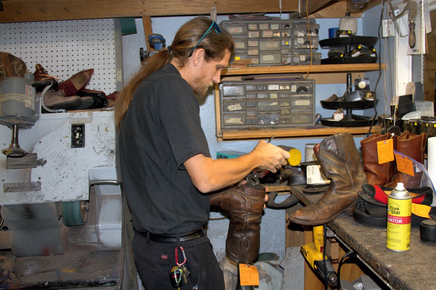 Lee Vaccaro puts a new heel on a cowboy boot at Gus and Company as his great-grandfather did in 1904.