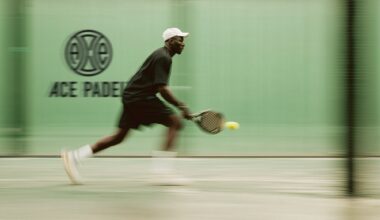 Photo of a man playing padel inside a room with green walls. A sign on the wall reads, "Ace Padel"