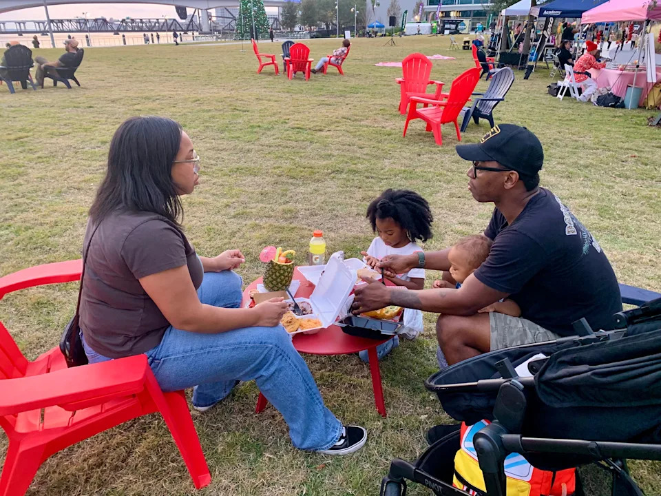 Kadeisha Jefferson and Jarvis Jefferson enjoy a family dinner at one of the tables on the great lawn of Riverfront Plaza on Dec. 5, 2025. The park opened to the public.