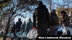 Residents stand in line to fill up bottles with fresh drinking water after critical infrastructure was hit by Russian attacks, Odesa, Ukraine December 13, 2025.