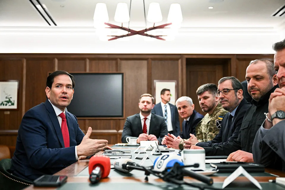Marco Rubio, left, sits across a table with many people on the other side (Chandan Khanna / AFP - Getty Images)
