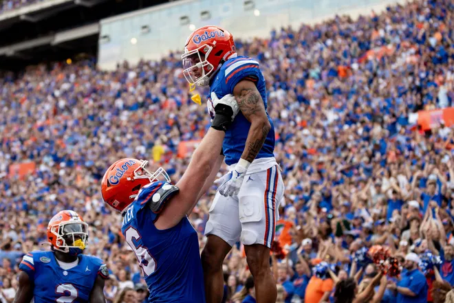 Florida Gators offensive lineman Jake Slaughter (66) holds up Florida Gators wide receiver Eugene Wilson III (3) after a touchdown during the second half at Steve Spurrier Field at Ben Hill Griffin Stadium in Gainesville, FL on Saturday, October 7, 2023. [Matt Pendleton/Gainesville Sun]