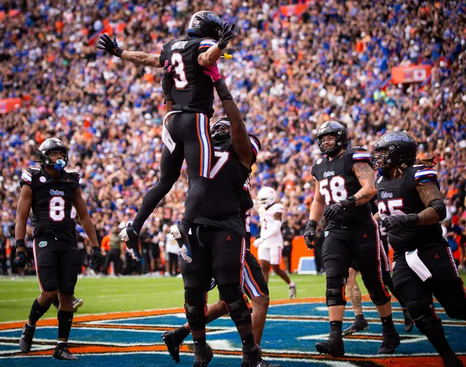 Florida Gators wide receiver Eugene Wilson III (3) is hoisted buy Florida Gators offensive lineman Knijeah Harris (77) after scoring a touchdown against Arkansas at Steve Spurrier Field at Ben Hill Griffin Stadium in Gainesville, FL on Saturday, November 4, 2023. [Doug Engle/Gainesville Sun]