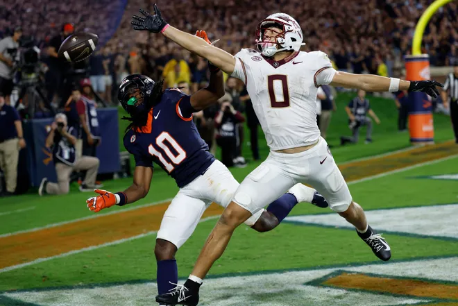 Sep 26, 2025; Charlottesville, Virginia, USA; Florida State Seminoles wide receiver Duce Robinson (0) attempts to catch a pass in the end zone as Virginia Cavaliers defensive back Ja'son Prevard (10) defends during the fourth quarter at Scott Stadium. Mandatory Credit: Geoff Burke-Imagn Images