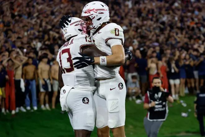 Sep 26, 2025; Charlottesville, Virginia, USA; Florida State Seminoles tight end Randy Pittman Jr. (13) celebrates with Seminoles wide receiver Duce Robinson (0) after catching a game tying touchdown pass in the final minute during the fourth quarter in front of Virginia Cavaliers linebacker Kam Robinson (5) during the fourth quarter at Scott Stadium. Mandatory Credit: Geoff Burke-Imagn Images