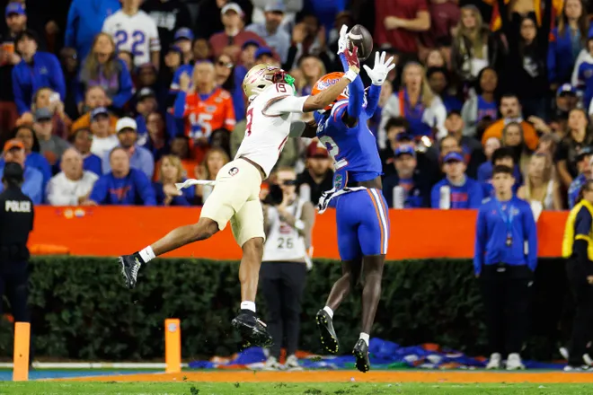 Nov 29, 2025; Gainesville, Florida, USA; Florida State Seminoles wide receiver Micahi Danzy (19) breaks up a pass to Florida Gators defensive back Ben Hanks III (12) during the first half at Ben Hill Griffin Stadium. Mandatory Credit: Matt Pendleton-Imagn Images