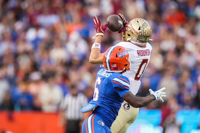 GAINESVILLE, FLORIDA - NOVEMBER 29: Duce Robinson #0 of the Florida State Seminoles catches a pass against J'Vari Flowers #6 of the Florida Gators during the first half of a game at Ben Hill Griffin Stadium on November 29, 2025 in Gainesville, Florida. (Photo by James Gilbert/Getty Images)