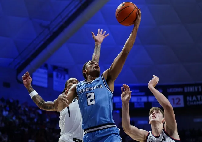 Nov 10, 2025; Storrs, Connecticut, USA; Columbia Lions guard Kenny Noland (2) drives to the basket against UConn Huskies guard Solo Ball (1) and center Eric Reibe (12) in the first half at Harry A. Gampel Pavilion.