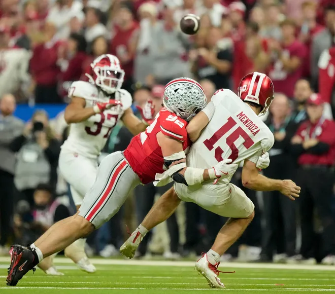 Ohio State Buckeyes defensive end Caden Curry (92) wraps up Indiana Hoosiers quarterback Fernando Mendoza (15) on Saturday, Dec. 6, 2025, during the Big Ten football championship at Lucas Oil Stadium in Indianapolis.