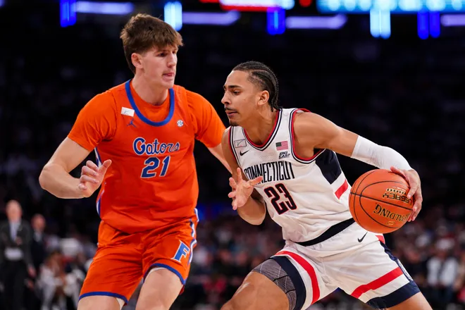 NEW YORK, NEW YORK - DECEMBER 09: Jayden Ross #23 of the UConn Huskies drives to the basket as Alex Condon #21 of the Florida Gators defends in the first half at Madison Square Garden on December 09, 2025 in New York City. (Photo by Evan Bernstein/Getty Images)