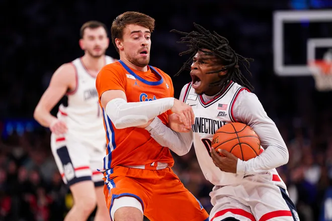 NEW YORK, NEW YORK - DECEMBER 09: Malachi Smith #0 of the UConn Huskies drives against Urban Klavzar #7 of the Florida Gators in the first half at Madison Square Garden on December 09, 2025 in New York City. (Photo by Evan Bernstein/Getty Images)