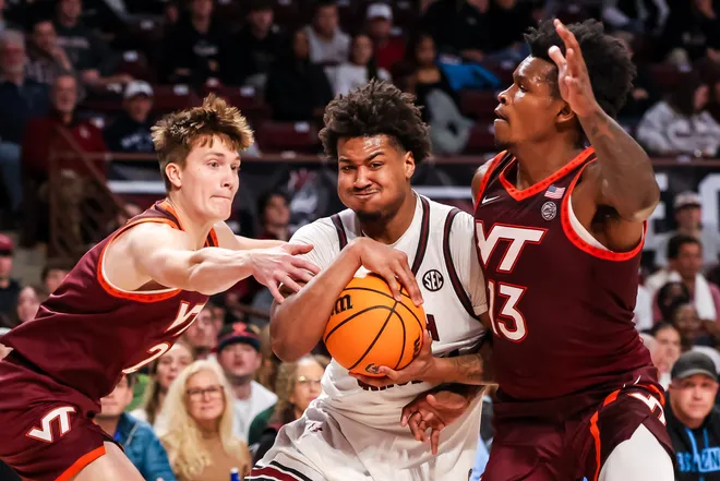 Dec 2, 2025; Columbia, South Carolina, USA; South Carolina Gamecocks forward Elijah Strong (31) drives between Virginia Tech Hokies guard Jaden Schutt (2) and forward Amani Hansberry (13) in the first half at Colonial Life Arena. Mandatory Credit: Jeff Blake-Imagn Images