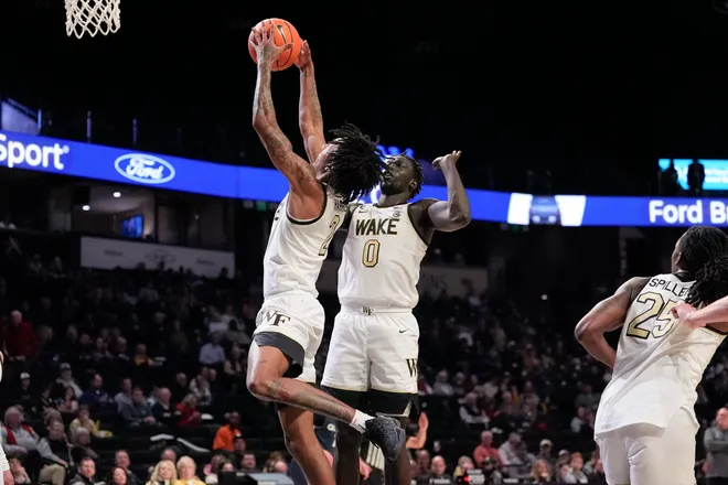 Dec 14, 2025; Winston-Salem, North Carolina, USA; Wake Forest Demon Deacons guard Juke Harris (2) grabs the rebound in front of forward Omaha Biliew (0) against the Queens University Royals during the second half at Lawrence Joel Veterans Memorial Coliseum. Mandatory Credit: Jim Dedmon-Imagn Images