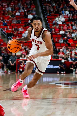 Dec 6, 2025; Raleigh, North Carolina, USA; NC State Wolfpack guard Alyn Breed (7) dribbles with the ball during the first half of the game against Liberty Flames at Lenovo Center. Mandatory Credit: Jaylynn Nash-Imagn Images