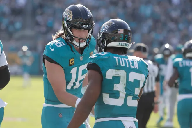 Dec 14, 2025; Jacksonville, Florida, USA; Jacksonville Jaguars quarterback Trevor Lawrence (16) and running back Bhayshul Tuten (33) react after scoring a touchdown during the second quarter against the New York Jets at EverBank Stadium. Mandatory Credit: Travis Register-Imagn Images