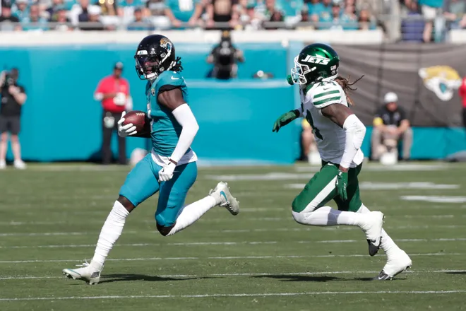 Dec 14, 2025; Jacksonville, Florida, USA; Jacksonville Jaguars wide receiver Brian Thomas Jr. (7) carries the ball against New York Jets linebacker Jamien Sherwood (44) during the first quarter at EverBank Stadium. Mandatory Credit: Travis Register-Imagn Images