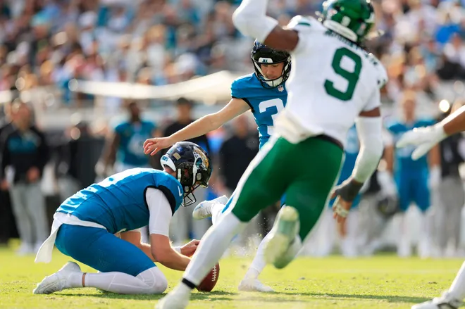 Jacksonville Jaguars place kicker Cam Little (39) kicks point after try as punter Logan Cooke (9) holds during the third quarter of a NFL football matchup at EverBank Stadium, Sunday, Dec. 14, 2025, in Jacksonville, Fla. The Jaguars defeated the Jets 48-20. [Corey Perrine/Florida Times-Union]