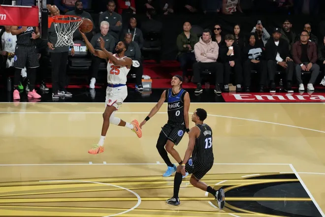 Dec 13, 2025; Las Vegas, Nevada, USA; New York Knicks guard Mikal Bridges (25) drives to the basket as Orlando Magic guard Anthony Black (0) and guard Jett Howard (13) look on during the second half at T-Mobile Arena.
